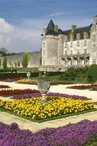 Jardins à la française fleuris devant le chateau, posté sur la roche