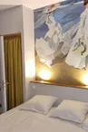 Chambre avec lit double et grande peinture au dessus du lit